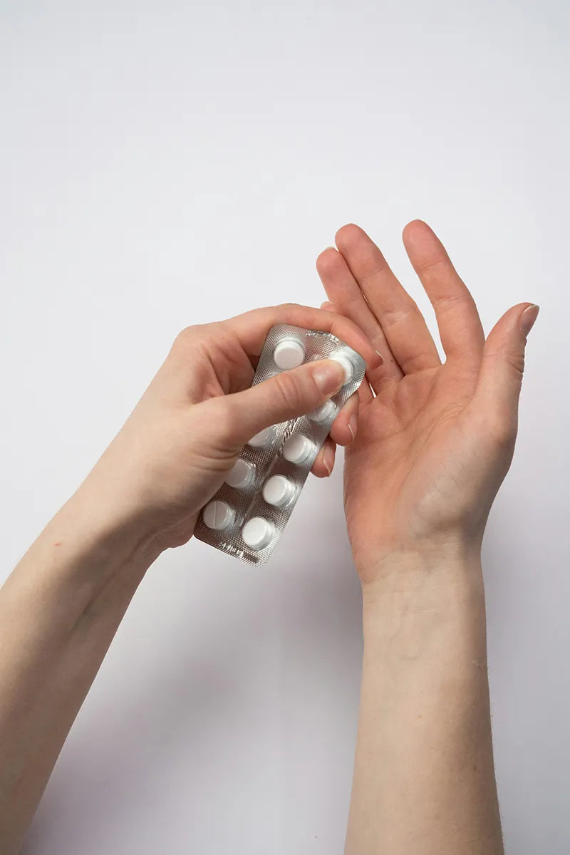 Young woman opens pill pack of Gabapentin.