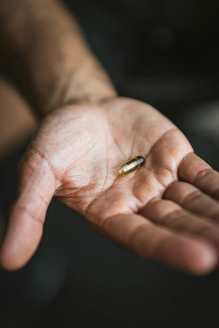 Man hold out a wellness capsule containing GABA. Photo by Rick Barrett